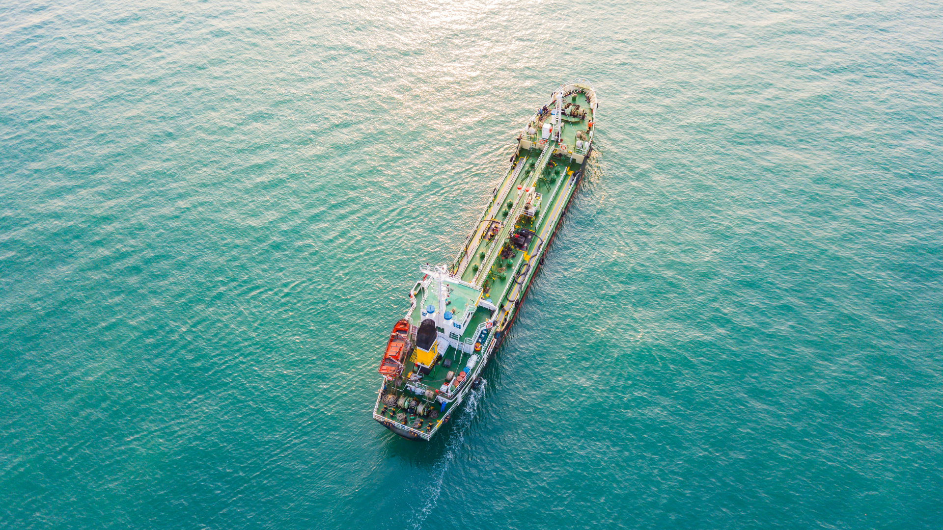 Vue aérienne d’un tanker pétrolier naviguant en mer, symbole du commerce international du pétrole et des tensions géopolitiques qui influencent les prix mondiaux.