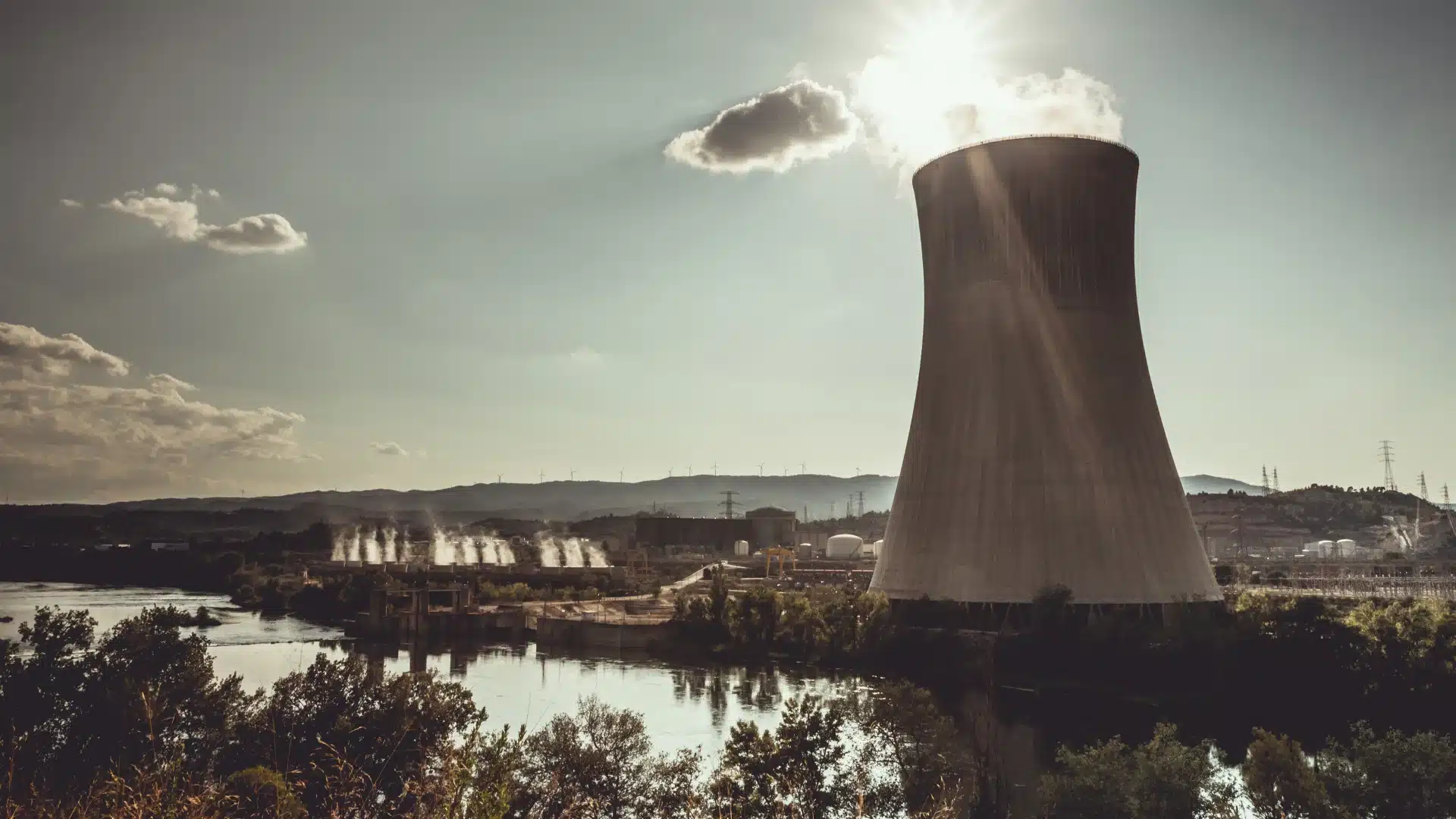 Centrale nucléaire au bord d’un fleuve, illustrant la production d’électricité et les enjeux liés à l’énergie.