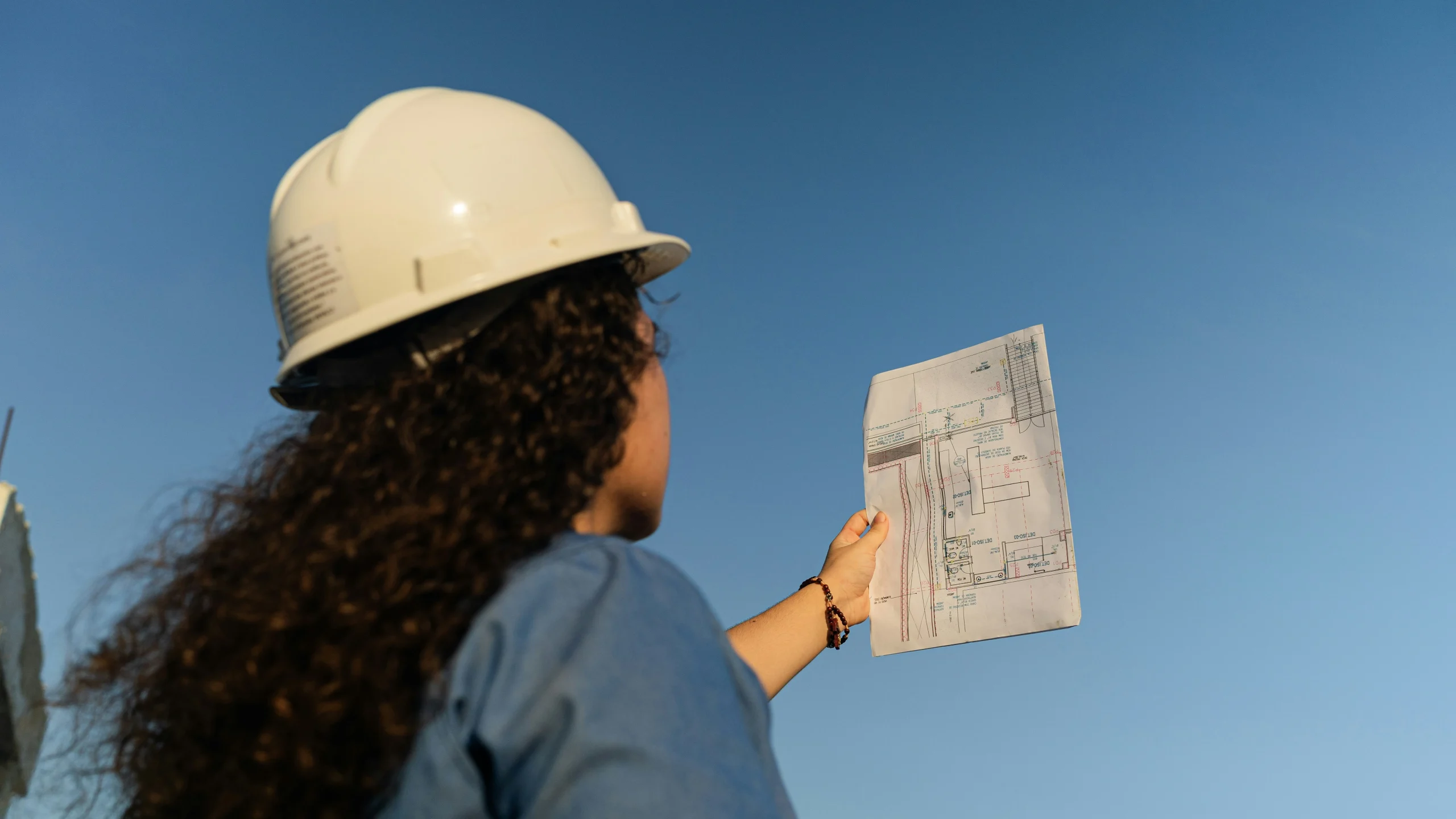 Technicienne réalisant un audit énergétique avec plan de bâtiment