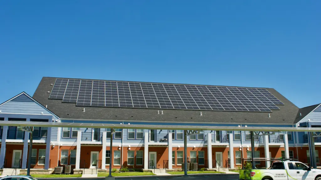 Panneaux solaires photovoltaïques en toiture et ombrières de parking équipant un bâtiment